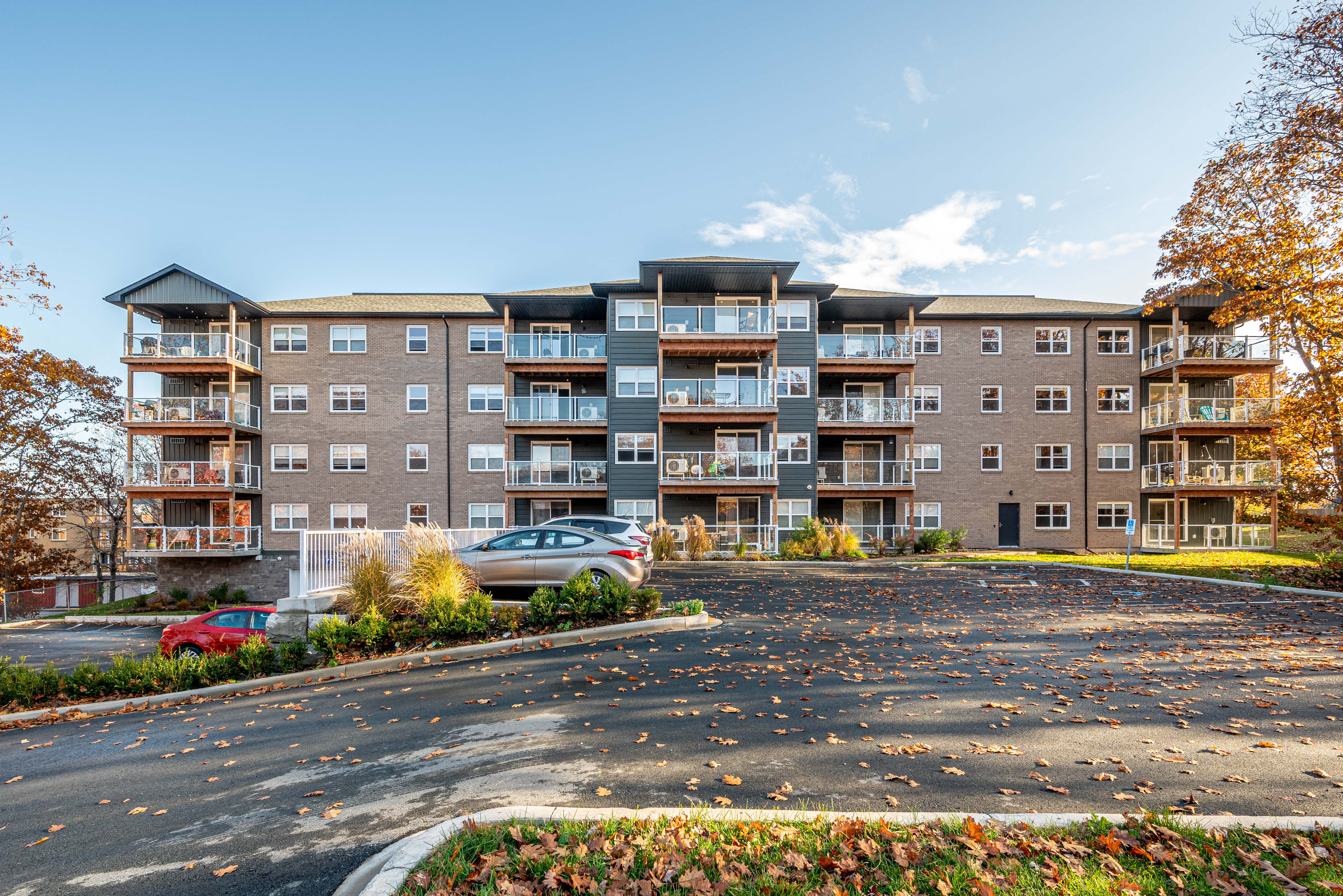 A large apartment complex with a parking lot in front.